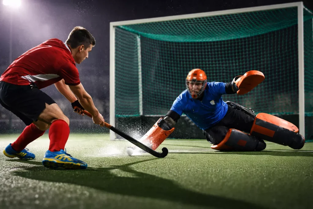 Hockeyspeler schiet op doel tijdens een aanval bij een Hoofdklasse-wedstrijd op kunstgras